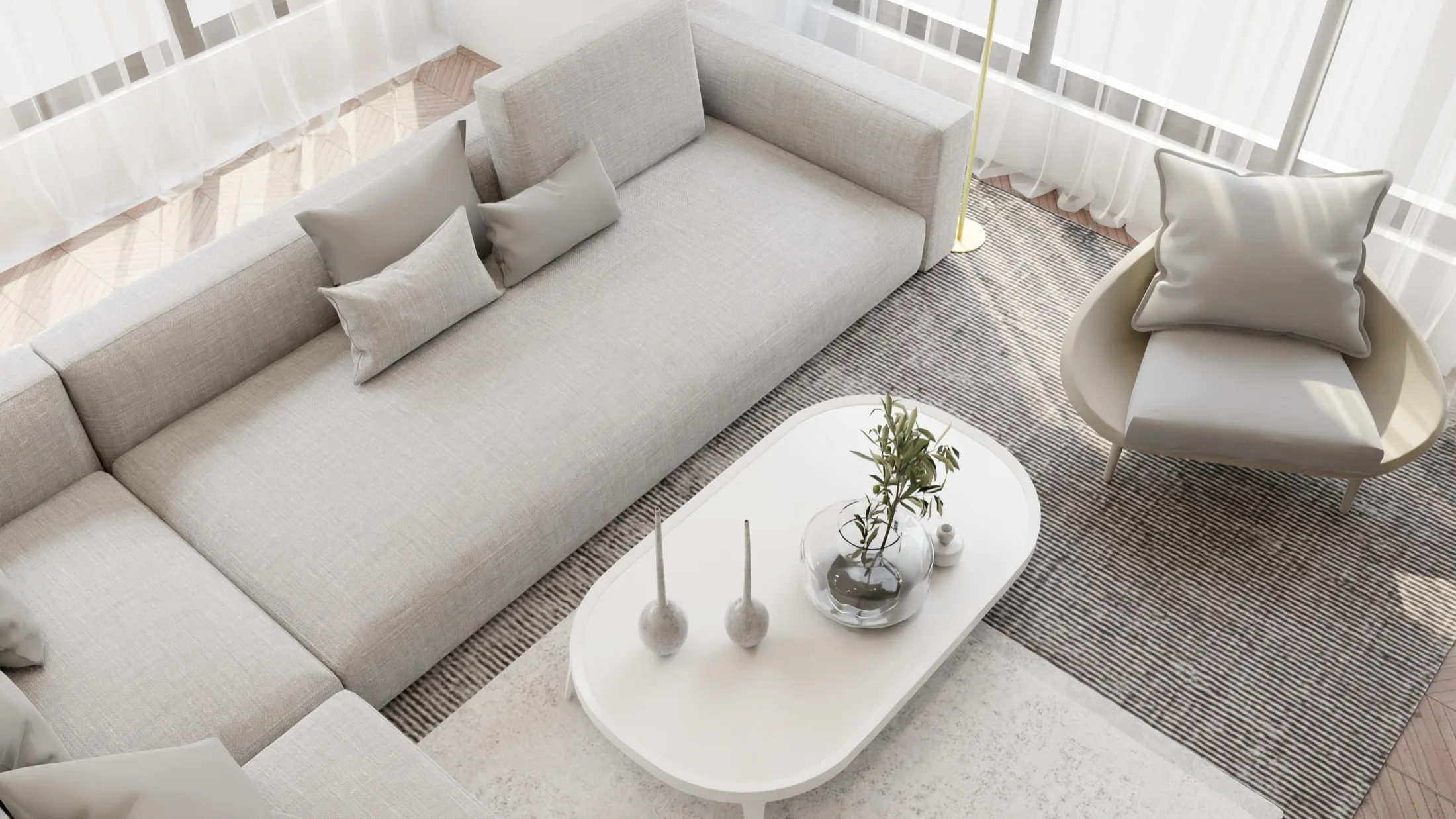 A calm living room with a deep sofa beside sheer-curtained windows